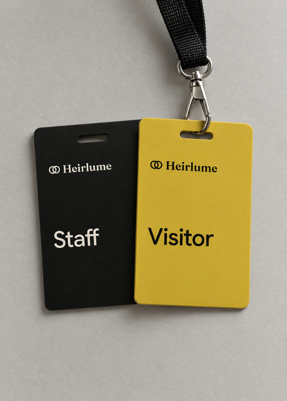 Heirlume visitor and staff badges, one yellow and one black