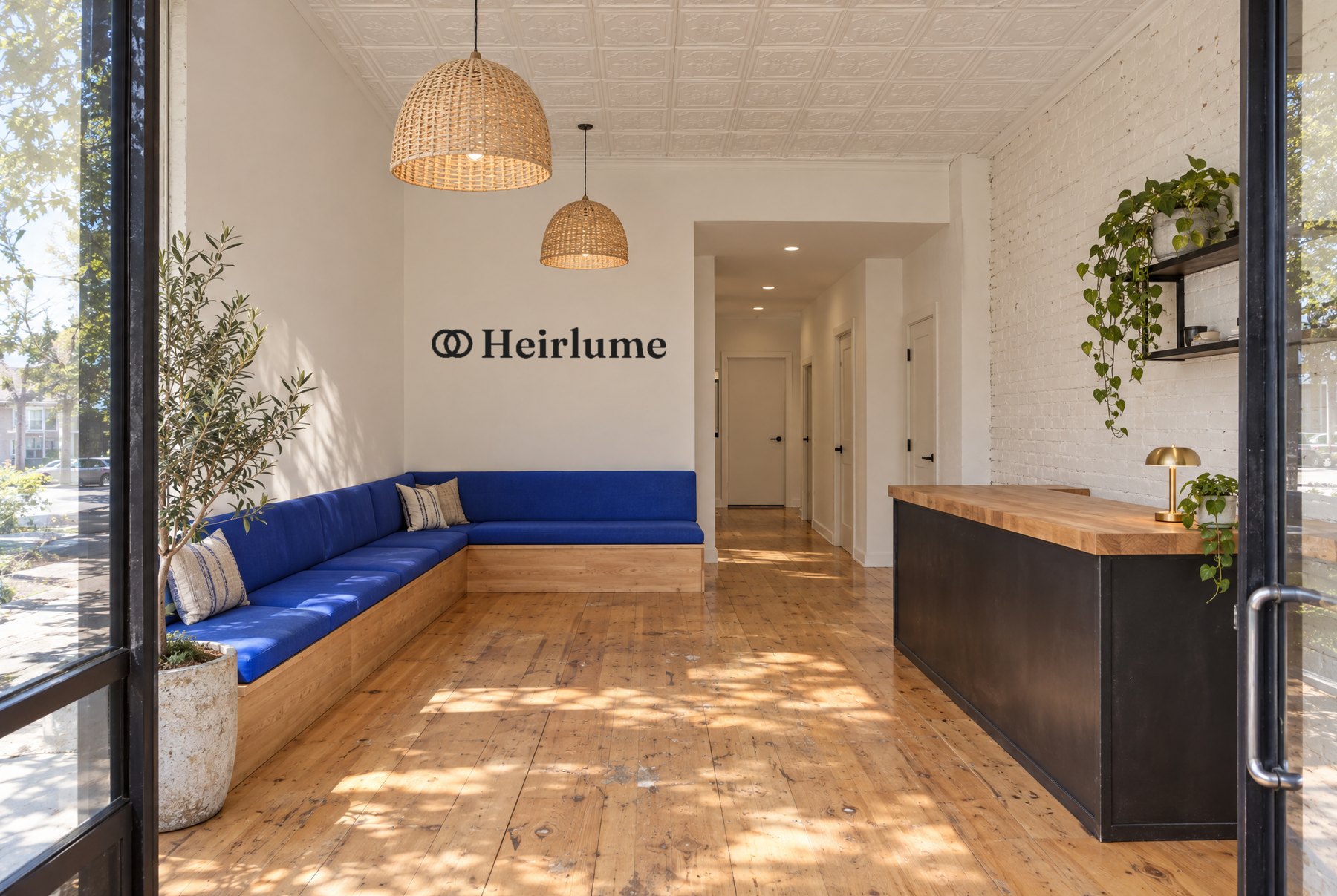 The lobby: the name on a white wall over a royal blue bench, a butcher-block counter, and pine floors in the sun
