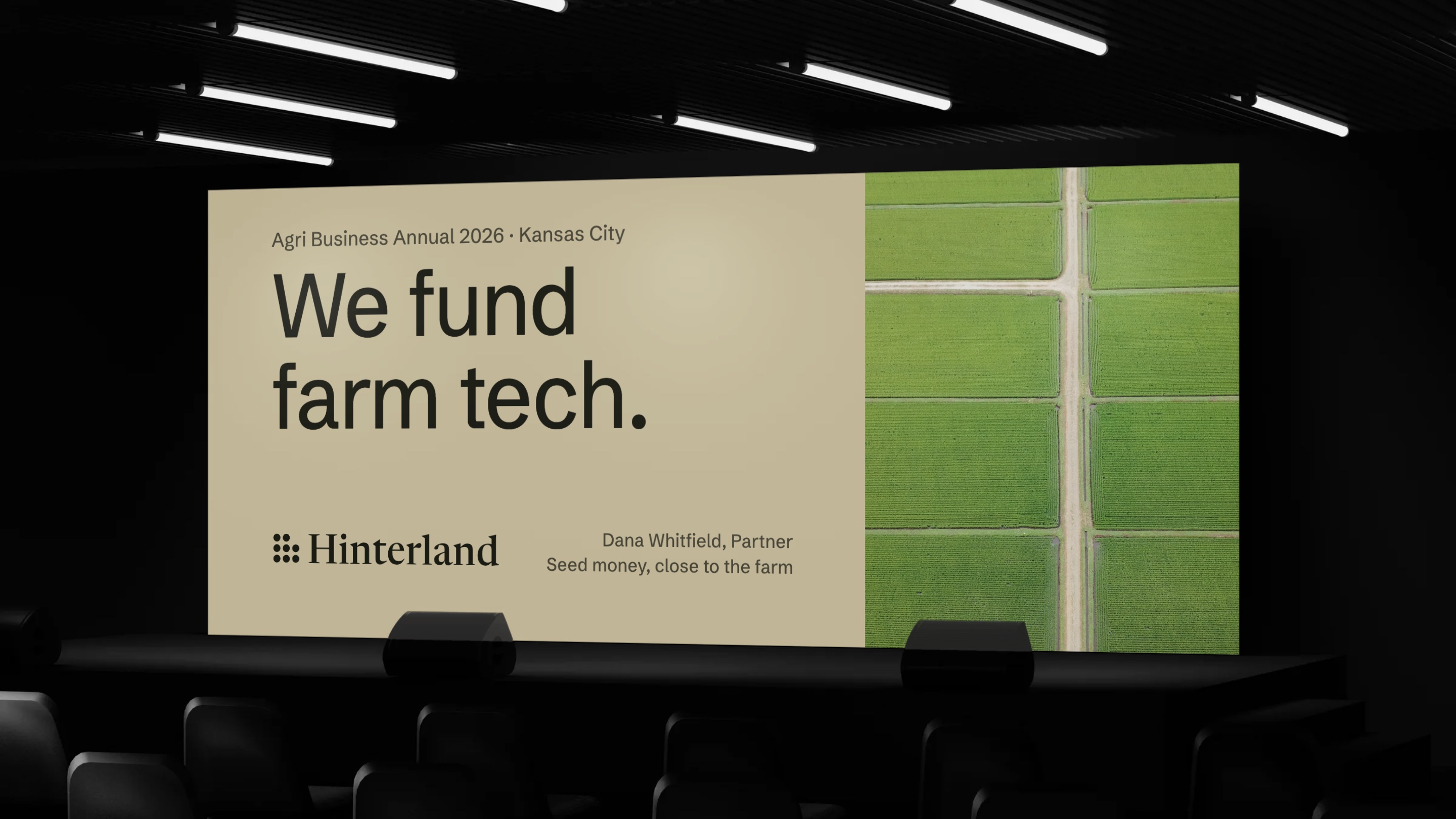 We fund farm tech, on the screen at a farm business conference, beside an aerial field